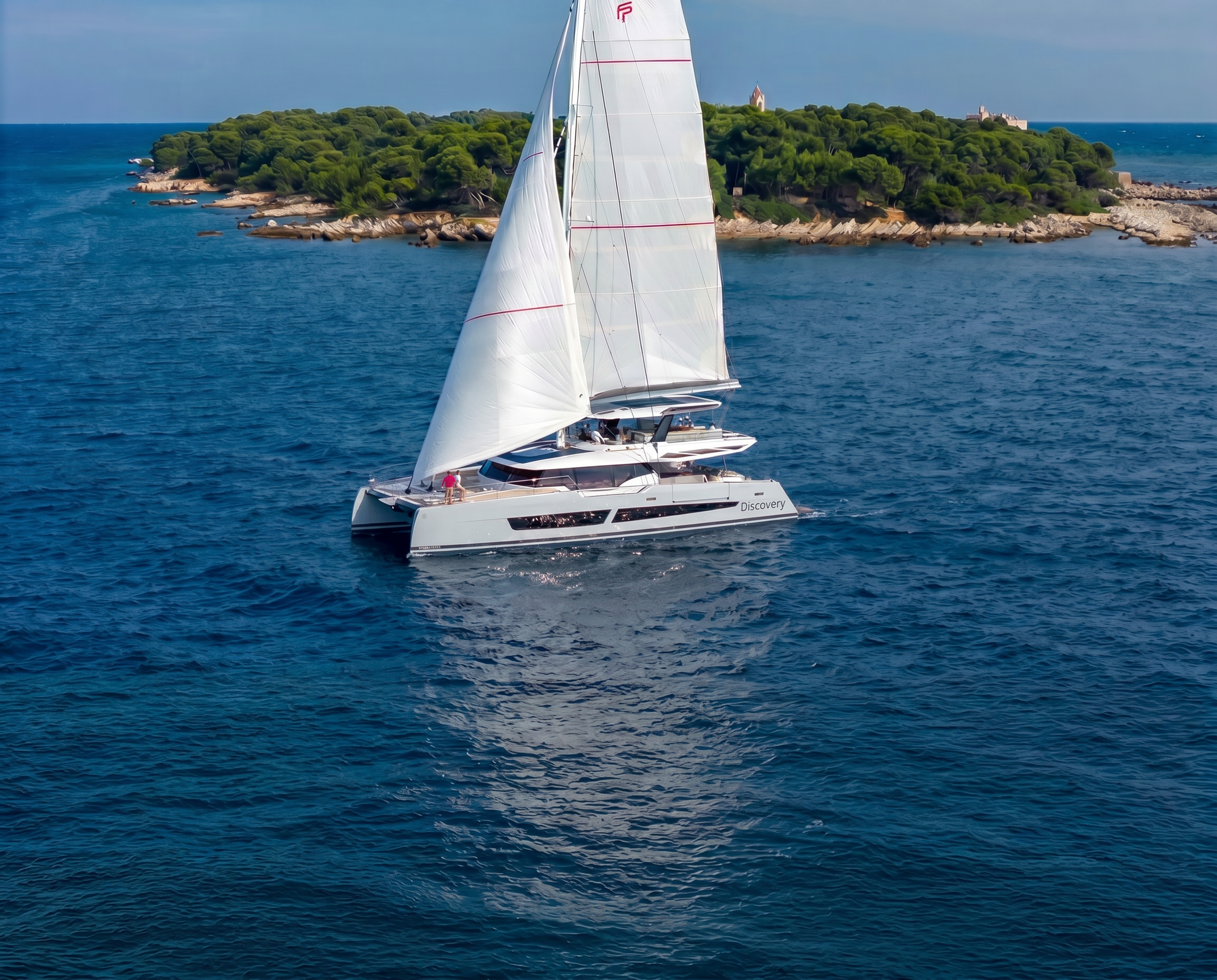 Aerial view of the Fountaine Pajot Thira 80 catamaran cruising under full sail across the open ocean